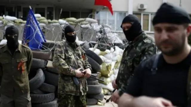 东南部港口城市马里乌波尔市政厅大楼外的亲俄武装分子。