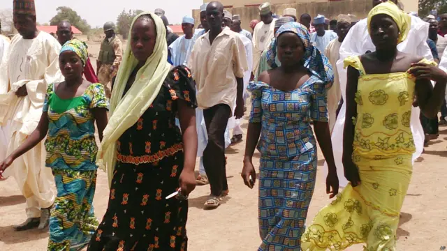 चरमपंथियों से छूटी लड़कियां और अन्य लोग प्रदर्शन करते हुए.