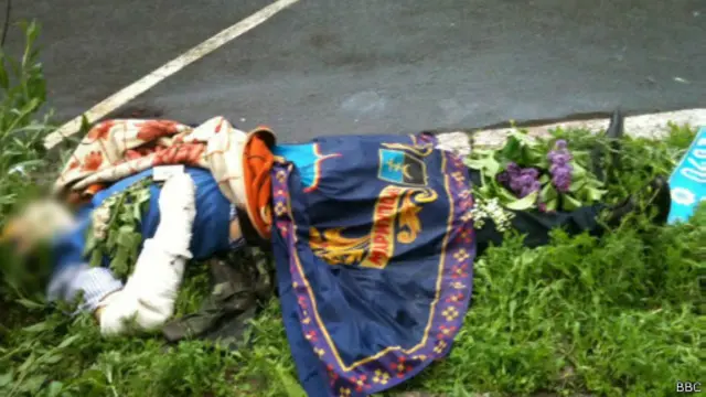 Мужчина лежит возле здания отделения милиции, где шли бои