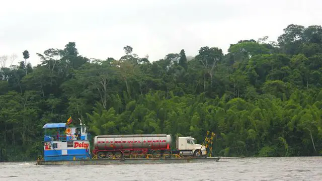 Embarcación transportando petróleo en un río amazónico