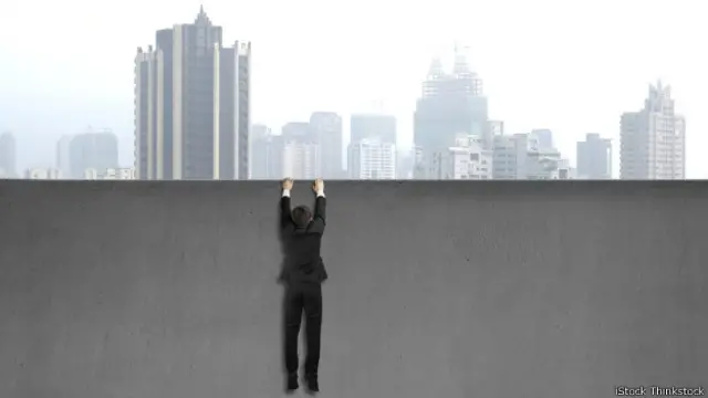 Un ejecutivo colgado de una pared