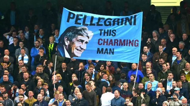 Los hinchas del Manchester City con una pancarta que lleva la imagen de Pellegrini y el mensaje "este hombre encantador"