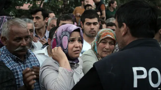 پولیسو د کان په شاخوا کې ټول شوي خلک کنترولول څو ژغورونکي وکولای شي چې په ښه توګه خپل کار پرمخ یوسي.
