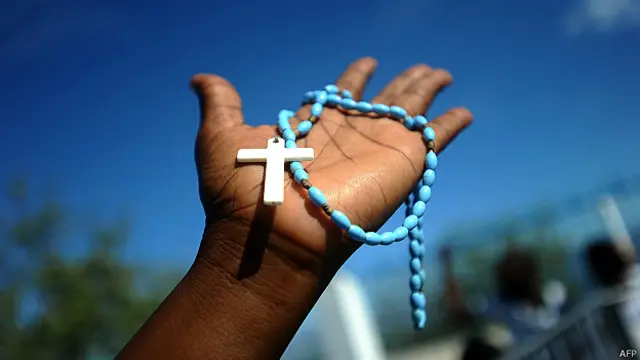 mujer sostiene un rosario