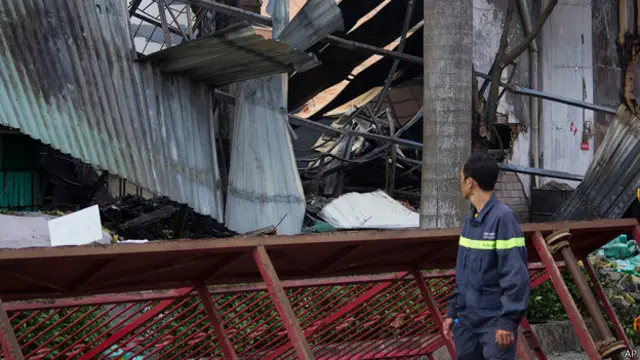 员工望着被毁厂房