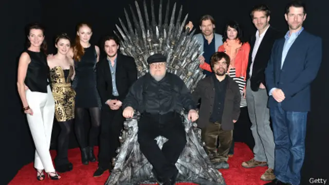 Martin en el trono de hierro con los actores de la serie televisiva