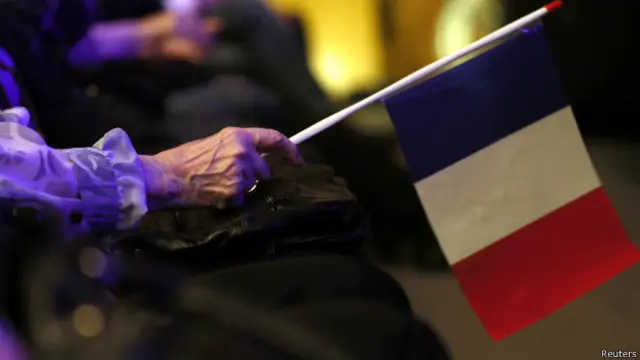 फ्रांस के राष्टीय झंडे के साथ नेशनल फ्रंट पार्टी का एक कार्यकर्ता