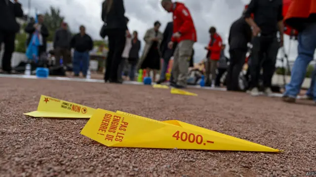 瑞士日内瓦劳工游行上一只带有支持最低工资标语的纸飞机躺于地上（7/5/2014）