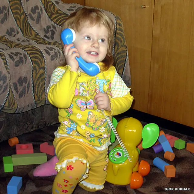 Девочка с игрушечным телефоном в виде слона