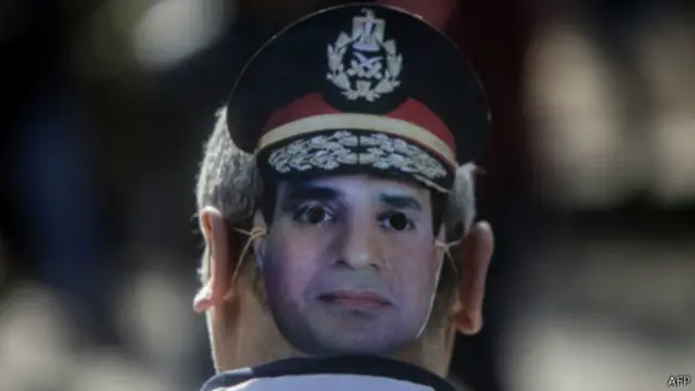 متظاهر يضع قناع عليه صورة السيسي