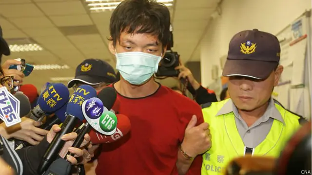 台北捷運襲擊案兇嫌鄭捷（中）在新北市的警察派出所被押走（台灣中央社圖片22/5/2014）