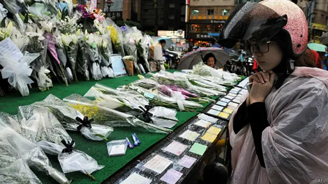 新北市台北捷運江子翠站外一位女途人朝著臨時花壇默哀悼念死難者（22/5/2014）