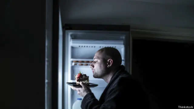 Hombre comiendo en la noche