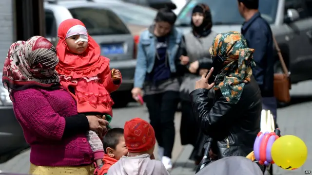 乌鲁木齐某清真寺外等候丈夫与孩子的维族妇女（23/5/2014）