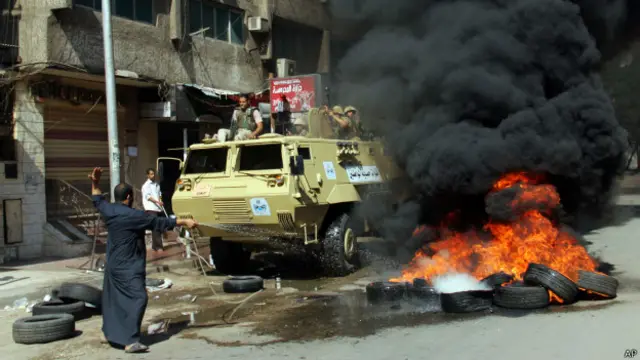 أحد المواطنين يحاول إطفاء إطارات أحرقت خلال صدامات بين قوات الأمن وطلبة جامعة الأزهر الذين تظاهروا الجمعة ضد الانتخابات وترشح السيسي.