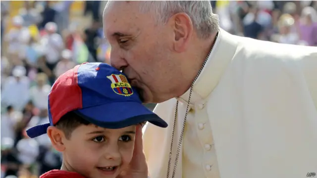البابا يقبل طفلا حضر القداس.