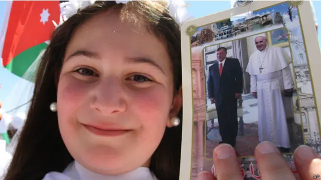 طفلة تحمل صورة البابا والملك الاردني بانتظار قدومه الى مكان القداس في ستاد عمان.