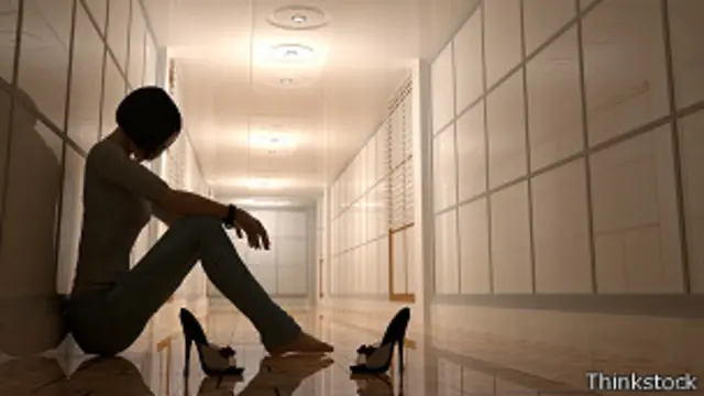 Mujer apoyada contra archivadores