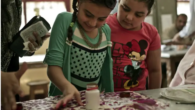 اصطحبت بعض السيدات أطفالهن إلى مراكز الاقتراع، فأخذ بعضهم يلهو بما رأى.