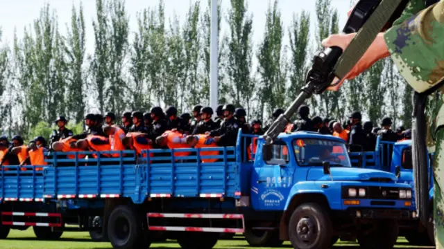 اصطف الجنود في حافلات على جانب مضمار للسباق في الملعب وهم يحمون المدانين.