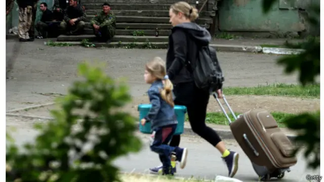 Люди бегут из дома около части, где идет бой