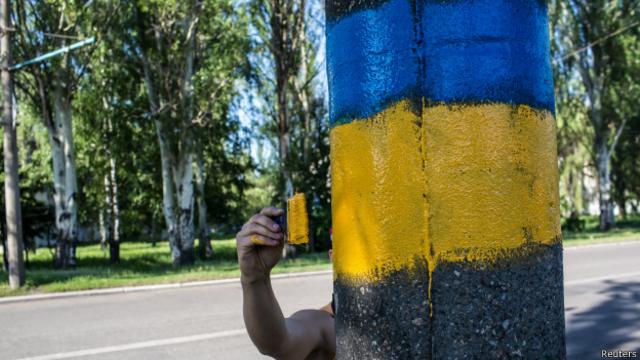рука рисует украинский флаг на дереве