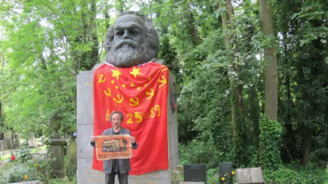 馬建在披上中國國旗後,展示他童年畫的馬恩列斯毛象,並當場撕掉。