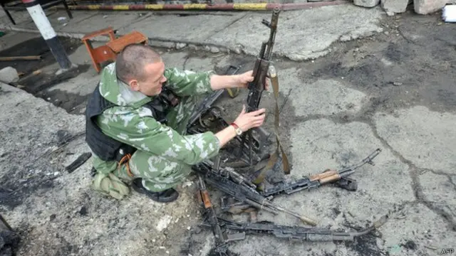 亲俄反叛战士在乌克兰国民卫队基地检查乌克兰军人丢下的枪支
