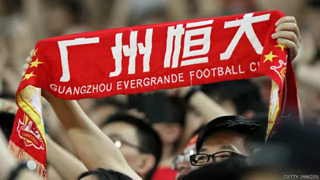 廣州天河體育中心內一名廣州恆大球迷舉起球會圍巾（22/4/2014）