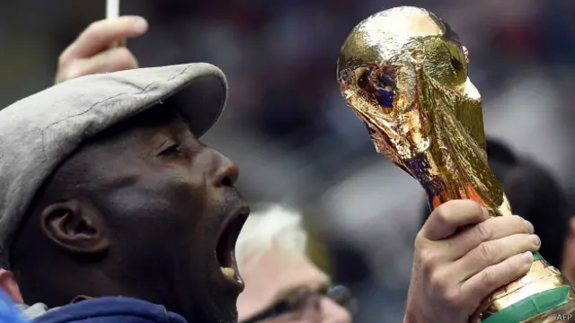 Hombre grita frente a modelo de la copa del Mundo