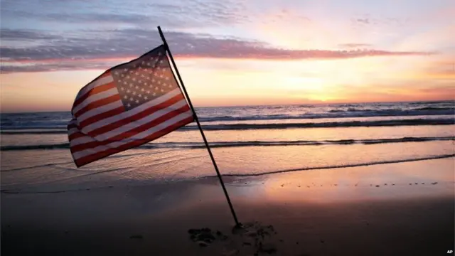 在美军登陆的奥马哈海滩，一面美国国旗在风中飘扬。