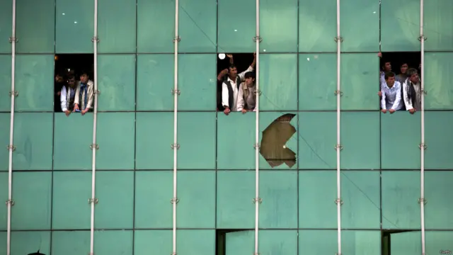 مردم مشغول تماشای خیابانی هستند که کاروان خودروهای همراه نامزد انتخابات آنجا منفجر شده