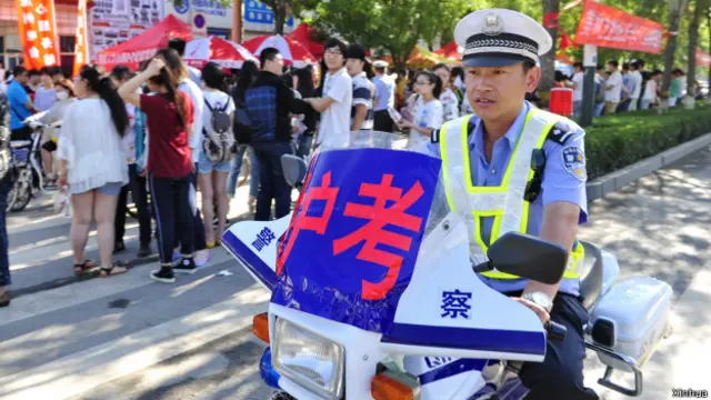 一名交警在河北沧州市第二中学考点外进行护考巡逻(07/06/2014)