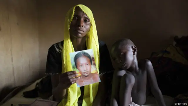 Mulher segura foto de filha sequestrada (Reuters)