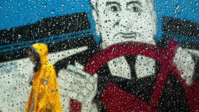 Женщина в дождевике под проливным дождем