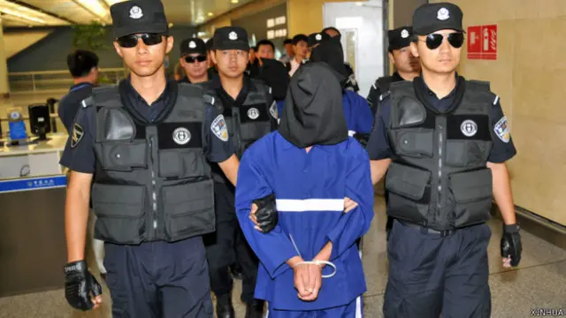 中国特警在云南昆明长水机场押解引渡自老挝的其中三名跨国贩毒案犯罪嫌疑人（新华社图片10/6/2014）