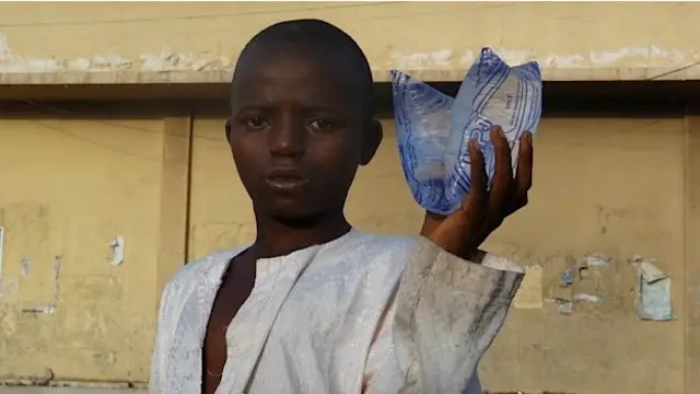 教育可以给穷人家的孩子提供一条出路。这是在卡诺街头卖水的男孩儿。