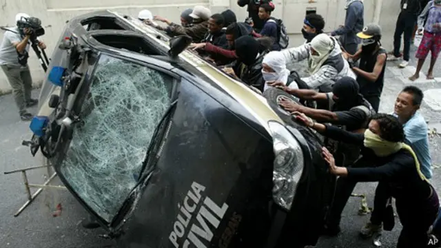 Manifestantes tumban un auto de la policía en Brasil