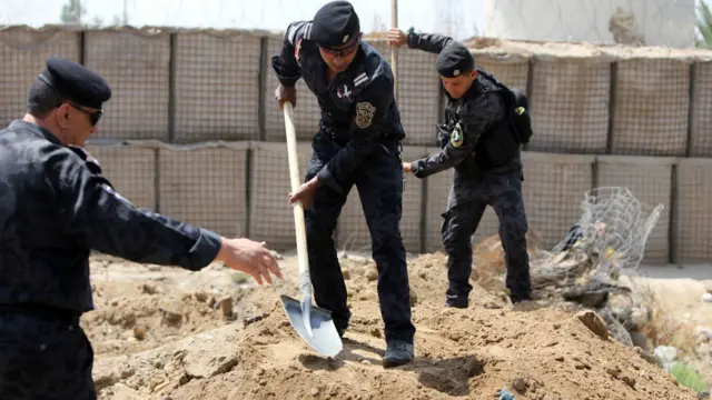 نیروهای پلیس عراق در یک ایستگاه بازرسی در ورودی شهر بغداد خندق می‌کنند