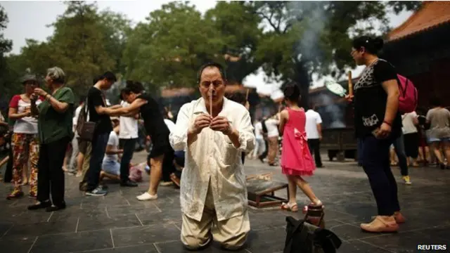 Sejumlah orang mendoaakan korban pesawat MH370.