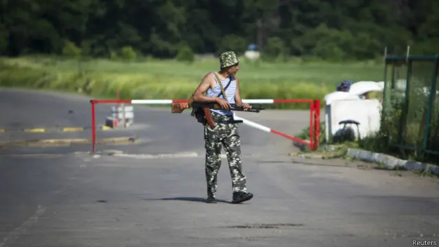 Anggota kelompok separatis pro-Rusia berjaga di dekat perbatasan. 