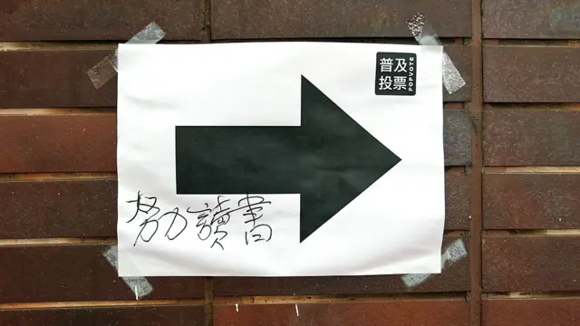 香港大學內一面「佔領中環」民間投票站指示牌被塗上「努力讀書」字眼（BBC中文網圖片22/6/2014）