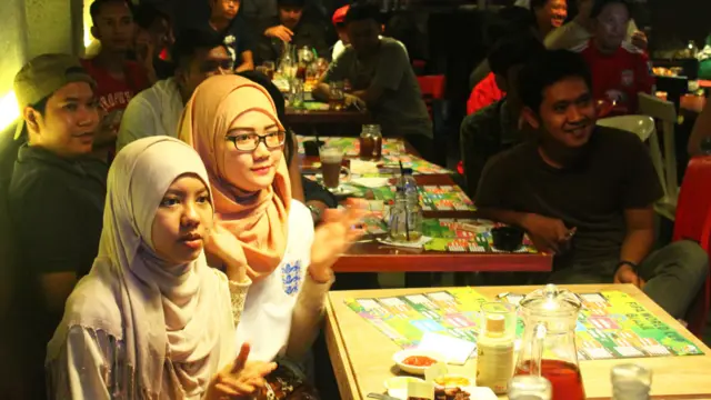 ইংল্যান্ড দুটি ম্যাচের পরেই আউট হয়ে গেলেও তাদের সমর্থকরা ছড়িয়ে রয়েছেন নানা দেশে। এখানে ইন্দোনেশিয়ার রাজধানী জাকার্তায় ক'জন ইংল্যান্ড সমর্থক। (ছবি: জেরোম ভিরাওয়ান, বিবিসি বাহ্‌সা ইন্দোনেশিয়া।)