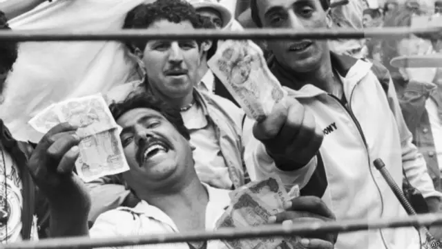 Suporter Aljazair mengacungkan uang sebagai protes atas laga "sandiwara" Jerbar V Austria.