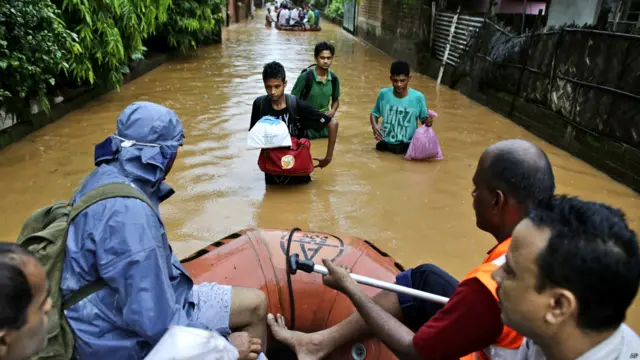 असम, बाढ़ प्रभावित इलाक़े, सुरक्षित इलाक़ो की तरफ़ जाते लोग