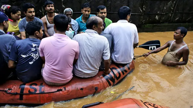 असम, बाढ़ प्रभावित इलाक़े, सुरक्षित इलाक़ो की तरफ़ जाते लोग