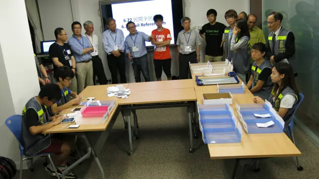 香港大学民意研究计划工作人员点算“占领中环”民间全民投票的纸张选票（BBC中文网图片29/6/2014）