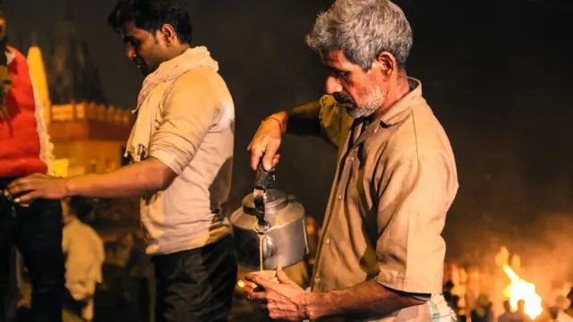 لالو یادیو کی دکان وارانسی شہر میں گنگا کے کنارے ایک شمشان گھاٹ کے قریب ہے اور انھوں نے ہزاروں کی تعداد میں کریا کرم دیکھے ہوں گے۔ لالو کے والد نے 40 سال قبل یہ چائے کی دکان شروع کی تھی تاکہ کریا کرم میں شریک ہونے والے لوگ یہاں کچھ لمحے بیٹھ کر چائے پی سکیں۔ 