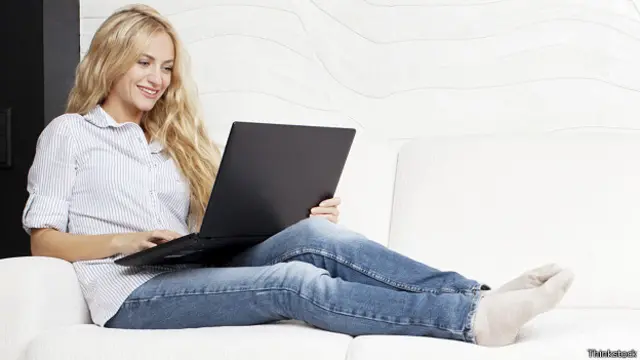 Девушка с ноутбуком на диване