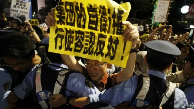टोक्यो में सुरक्षा नीति में सुधार का विरोध करते लोग